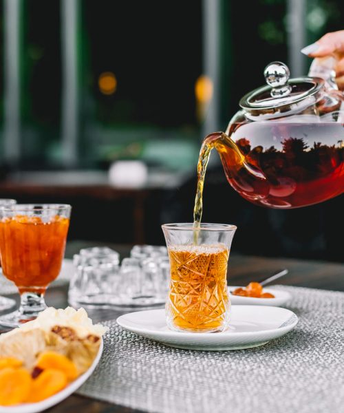 Front View Girl Pours Tea From Teapot Armoud Glass With Jam Sweets Table
